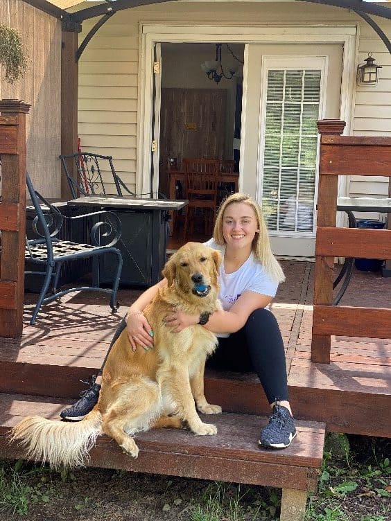 Person sitting with a Golden Retriever on porch