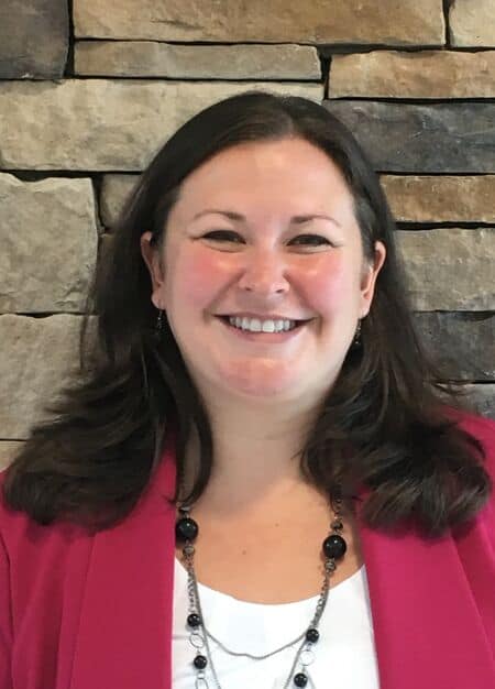 Smiling person against stone wall background.