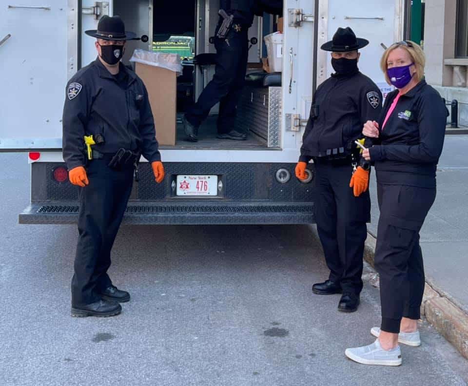 Police officers and woman by truck on street.