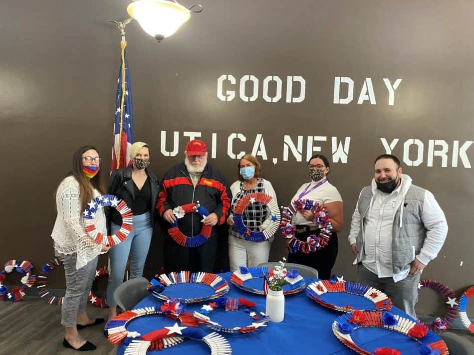 Group holding patriotic wreaths in Utica, New York.
