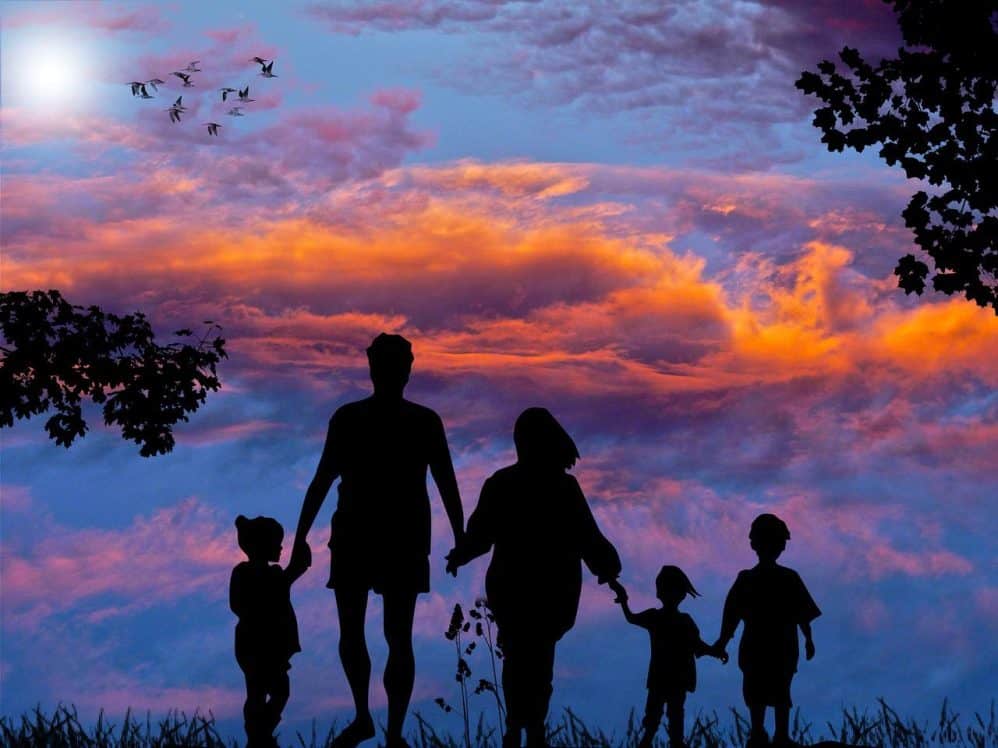 Family walking at sunset with colorful sky