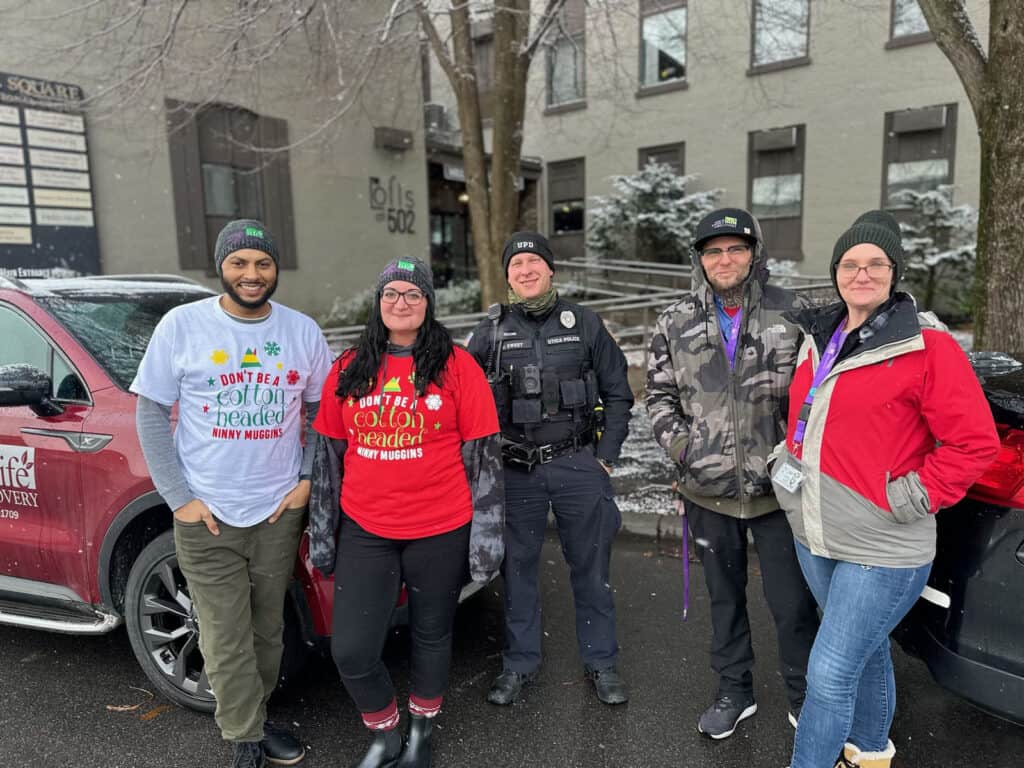 Smiling group poses outdoors in winter attire.