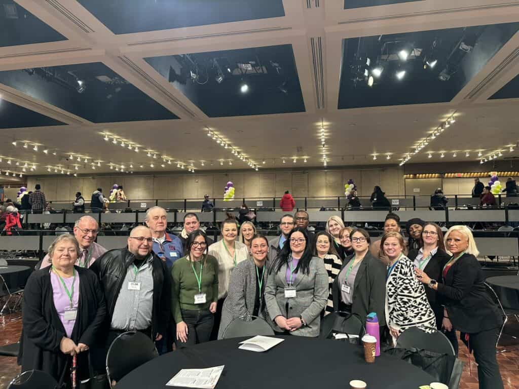 Group of people in a conference hall smiling.