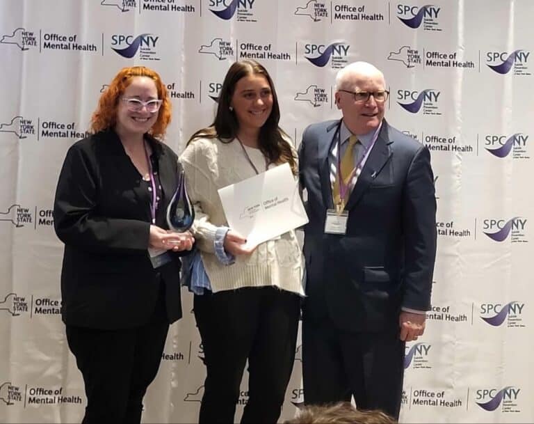 Three people at mental health award ceremony.