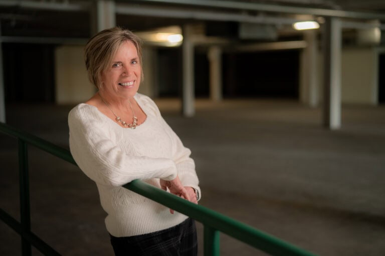 Smiling woman in a white sweater indoors.