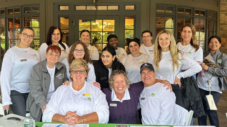 Group photo of smiling people wearing matching shirts.