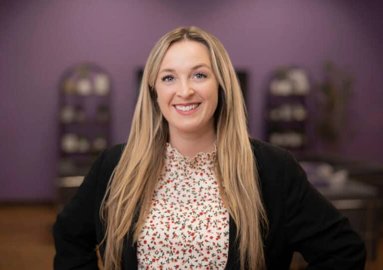 Smiling woman in floral blouse and black blazer