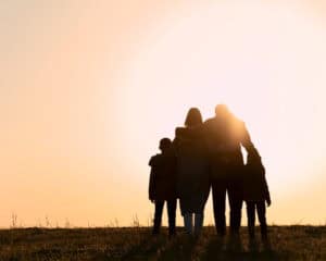 Family standing together at sunset