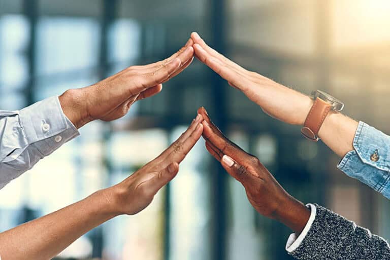 Four hands forming a pyramid shape.