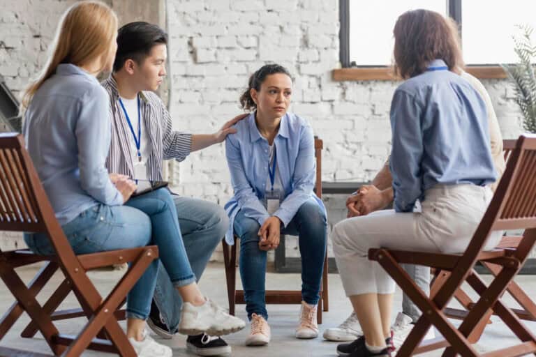 Support group meeting with five people discussing.