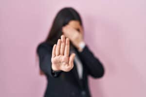 Person holding up hand, signaling stop