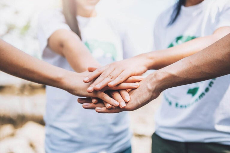 Group hands joined in teamwork support.
