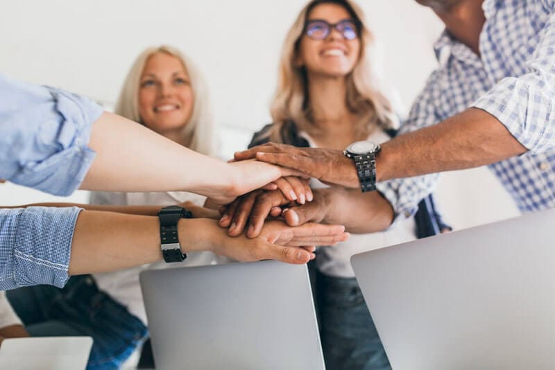 Team putting hands together in unity