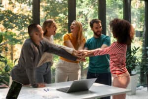 Group teamwork celebration in office environment.