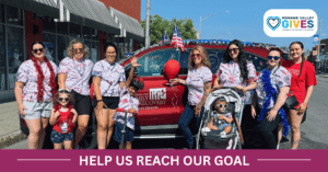 Community group celebrates beside decorated red vehicle
